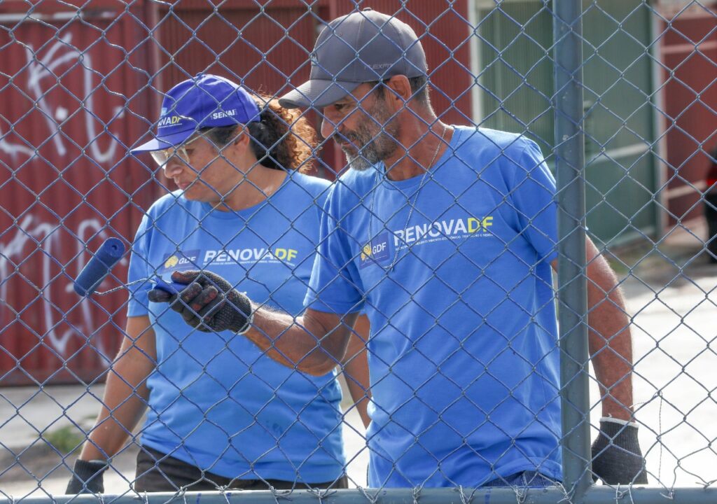 Participantes uniformizados do RenovaDF trabalham na manutenção de alambrado