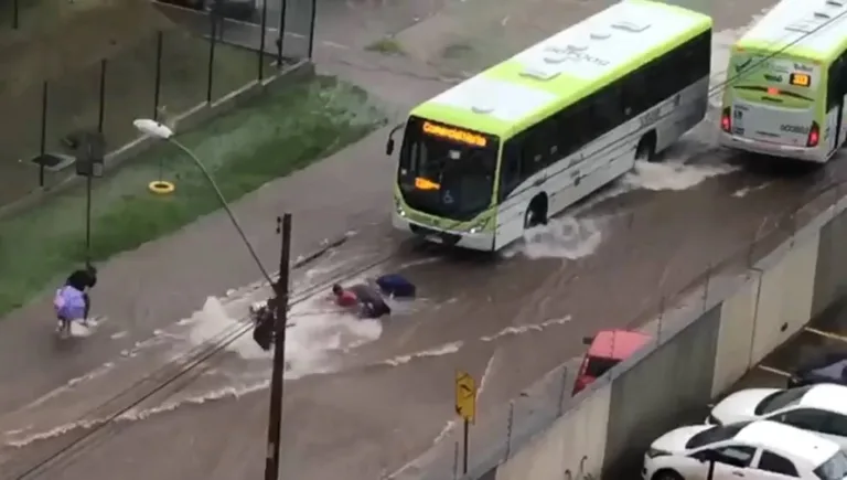 Vídeo: mulher vai parar embaixo de ônibus após cair em enxurrada no DF