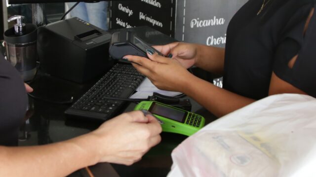 Trabalhadora em caixa de mercado em imagem sobre vagas de emprego no Distrito Federal