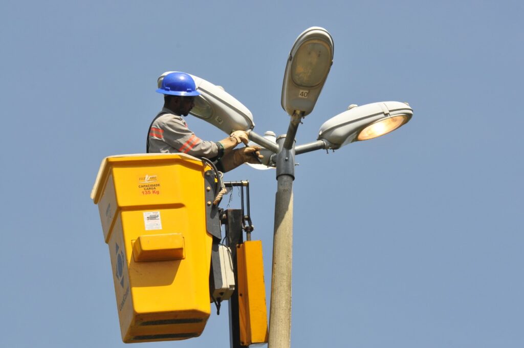 Trabalhador realiza manutenção em equipamento de iluminação pública