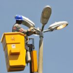 Trabalhador realiza manutenção em equipamento de iluminação pública