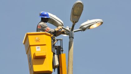 Trabalhador realiza manutenção em equipamento de iluminação pública