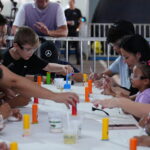 Crianças e familiares participam de experiência científica interativa