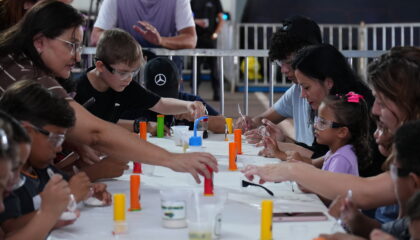 Crianças e familiares participam de experiência científica interativa