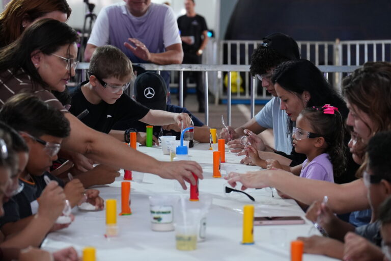 Crianças e familiares participam de experiência científica interativa