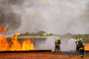 Bombeiros combatem chamas durante treinamento de emergência aeronáutica