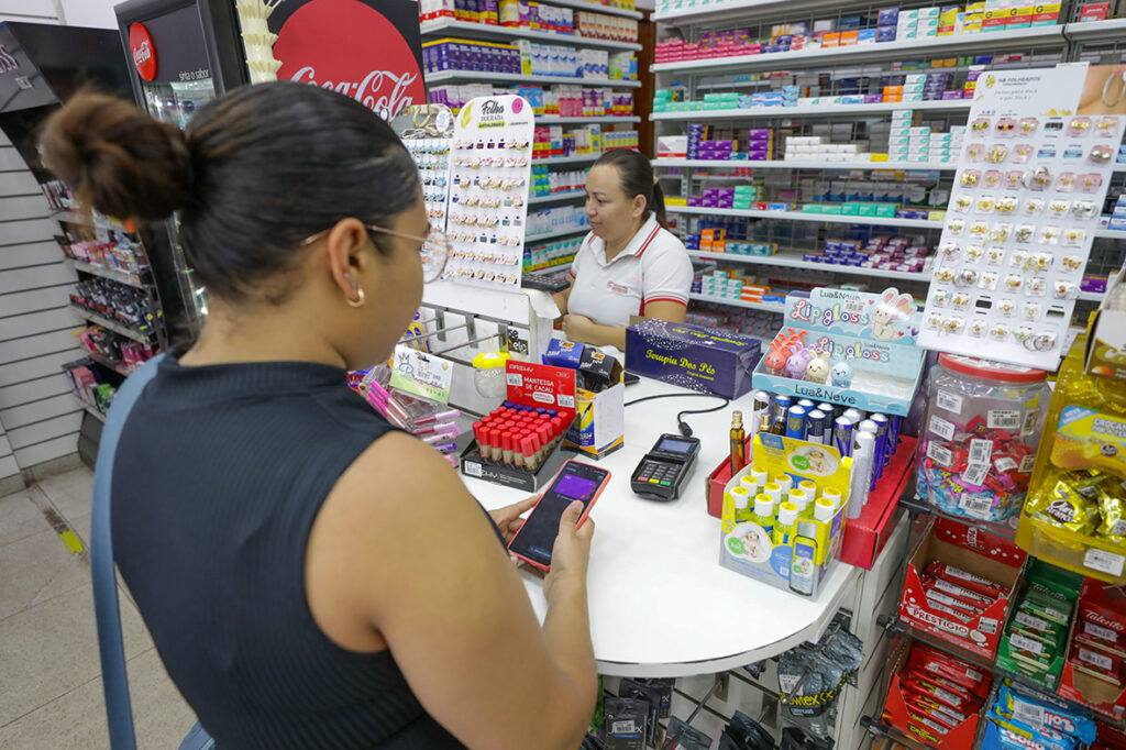 Operadora de caixa atende cliente em estabelecimento comercial do Distrito Federal