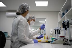 Profissionais analisam amostras em laboratório para auxiliar procedimentos de identificação