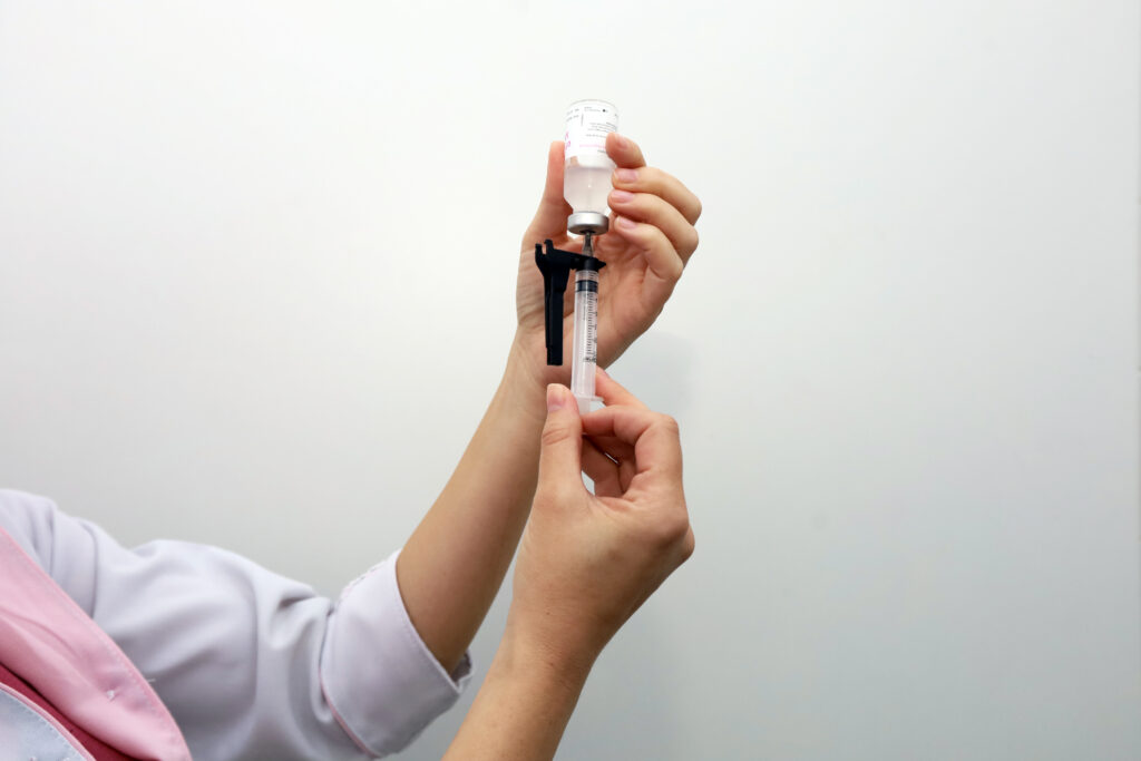 Profissional de saúde prepara uma dose de vacina para aplicação