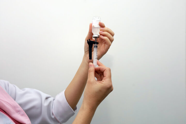 Profissional de saúde prepara uma dose de vacina para aplicação