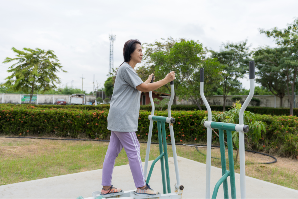 Mulher realiza exercício orientado em aparelho ao ar livre