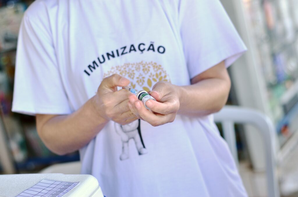 Profissional de saúde prepara uma dose de vacina durante ação de imunização