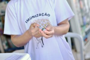 Profissional de saúde prepara uma dose de vacina durante ação de imunização