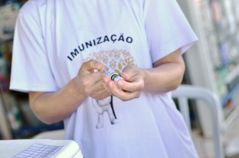 Profissional de saúde prepara uma dose de vacina durante ação de imunização