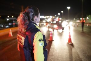 Agente do Detran-DF acompanha veículos com faróis acesos em via do Distrito Federal