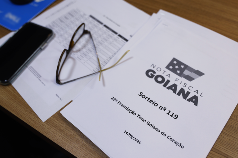 Documentos do sorteio 119 da Nota Fiscal Goiana sobre uma mesa