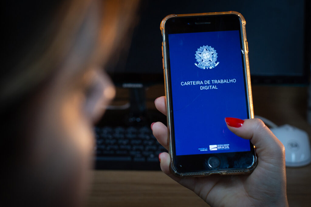 Pessoa segura celular com o aplicativo da Carteira de Trabalho Digital aberto
