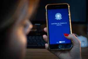 Pessoa segura celular com o aplicativo da Carteira de Trabalho Digital aberto