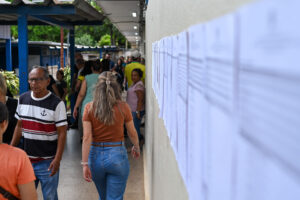 Eleitores circulam por corredor de local de votação ao lado de listas de seções