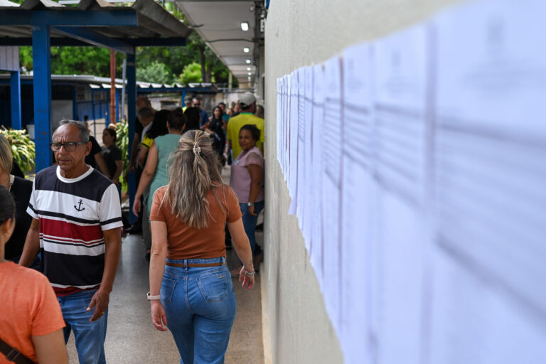 Eleitores circulam por corredor de local de votação ao lado de listas de seções