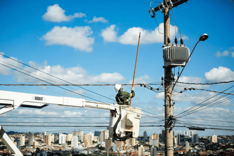 Trabalhador faz manutenção em poste da rede de distribuição de energia