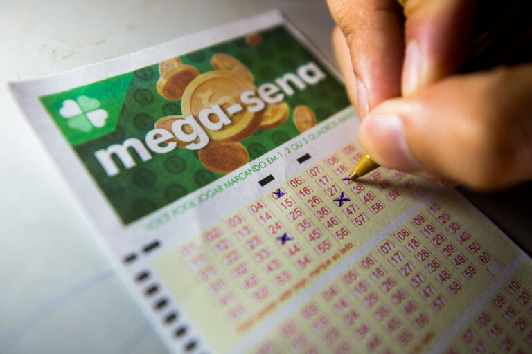Pessoa marca números em um volante da Mega-Sena