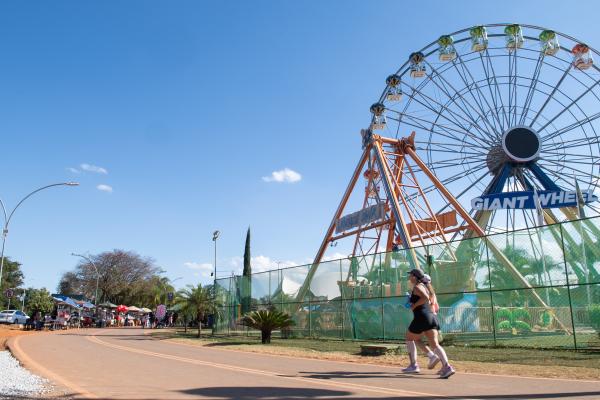 Pessoa corre em pista do Parque da Cidade diante de roda-gigante