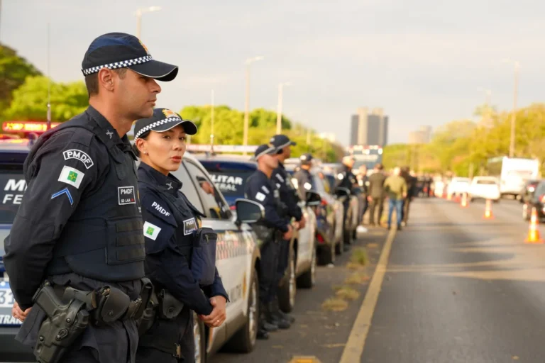Policiais militares diante de fila de novas viaturas da PMDF no Eixão Sul
