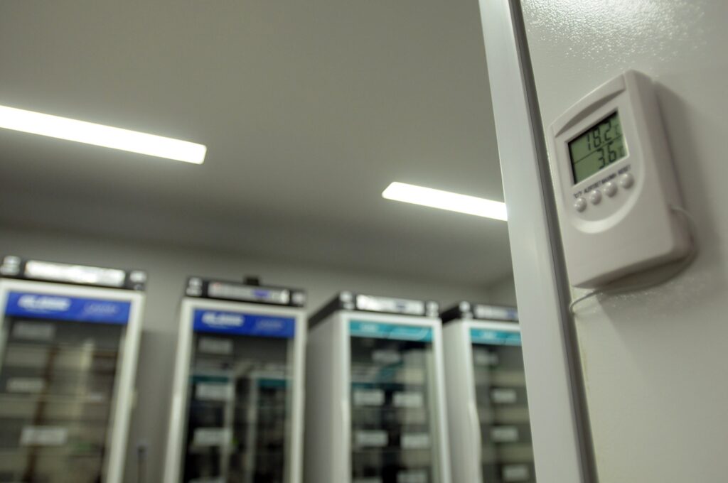 Termômetro digital registra a temperatura em sala com câmaras científicas para armazenamento de vacinas