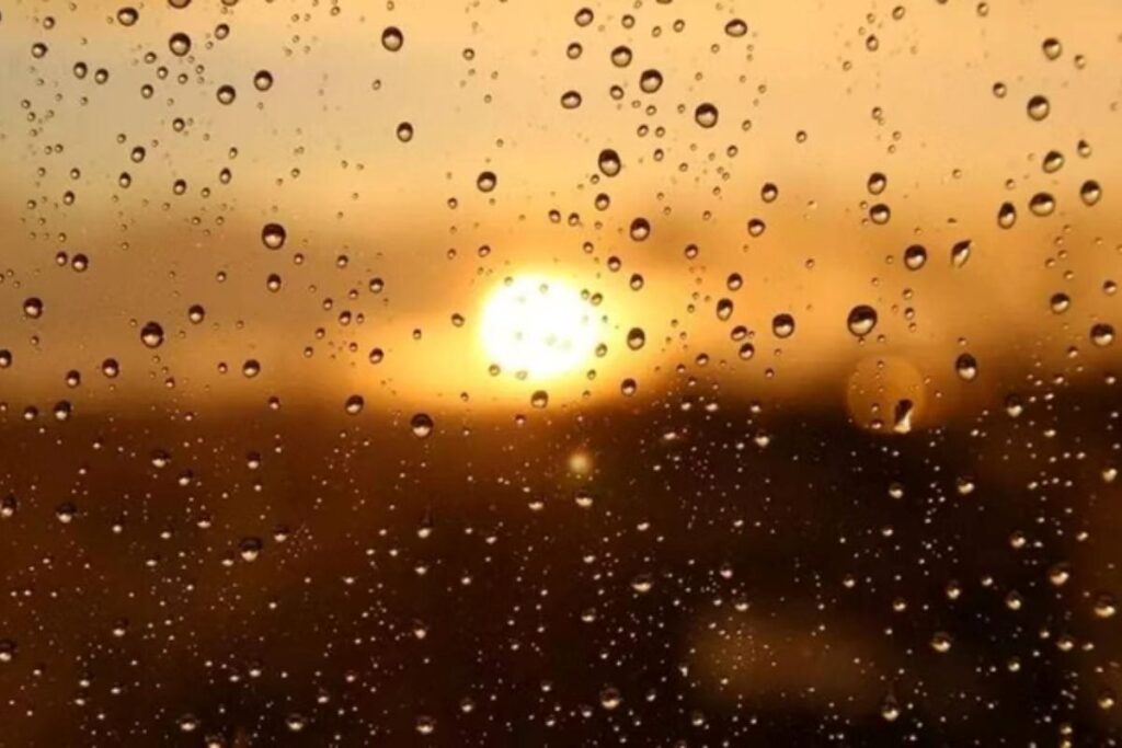 Gotas de chuva em vidro diante do sol entre nuvens
