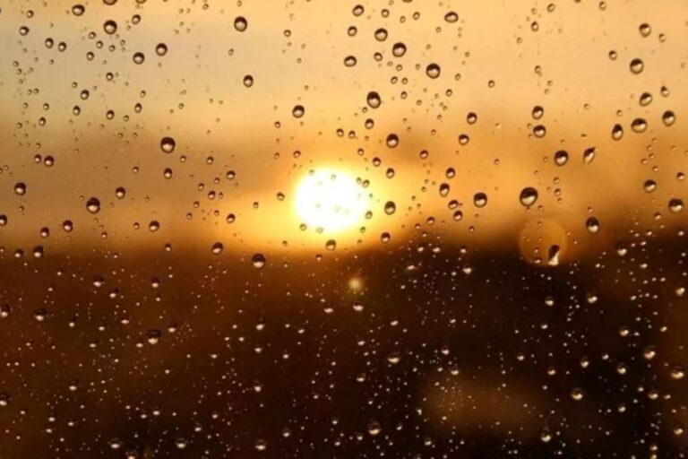 Gotas de chuva em vidro diante do sol entre nuvens