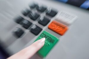 Eleitor pressiona a tecla confirma de uma urna eletrônica